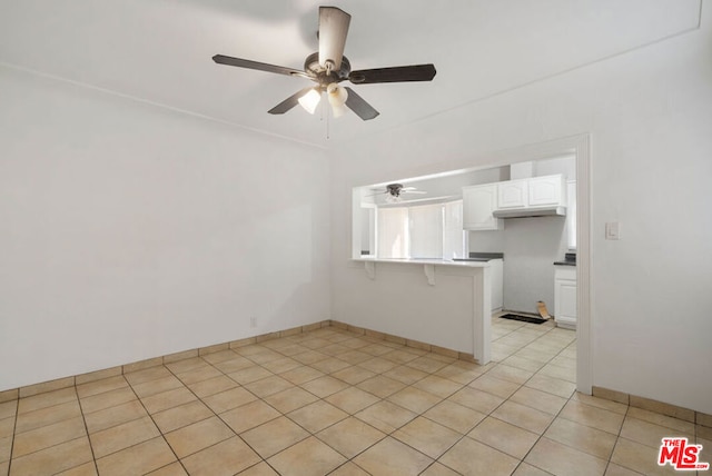 tiled spare room featuring ceiling fan