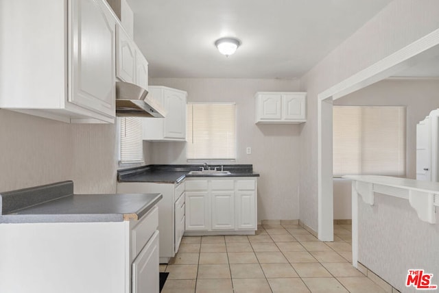 kitchen with sink, white cabinets, and light tile patterned floors