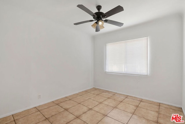 empty room with ceiling fan and light tile patterned flooring