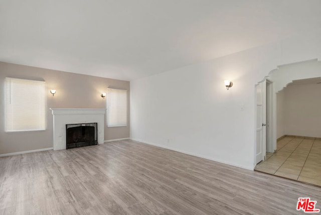 unfurnished living room featuring light hardwood / wood-style flooring and a healthy amount of sunlight