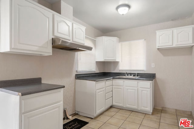 kitchen featuring white cabinets, light tile patterned floors, and sink