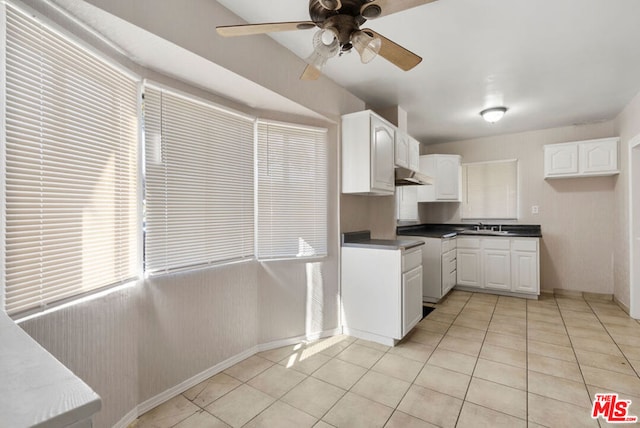 kitchen featuring ceiling fan, white cabinetry, sink, and light tile patterned floors