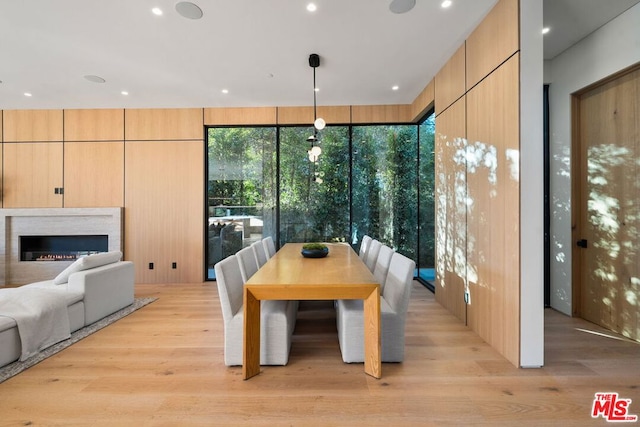 dining space featuring a wall of windows and light hardwood / wood-style floors