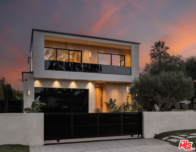 contemporary house featuring a garage and a balcony