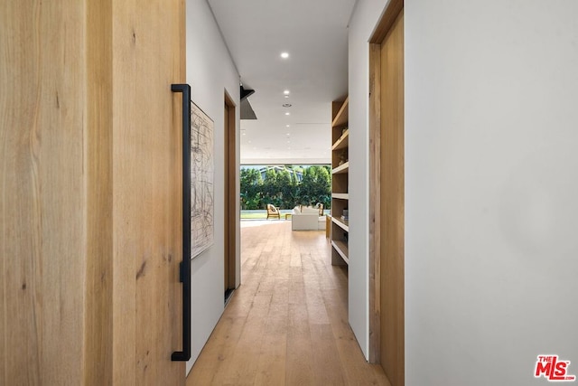 corridor with light hardwood / wood-style floors and floor to ceiling windows