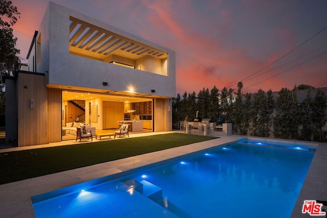 pool at dusk featuring area for grilling, an outdoor living space, a patio area, and a lawn