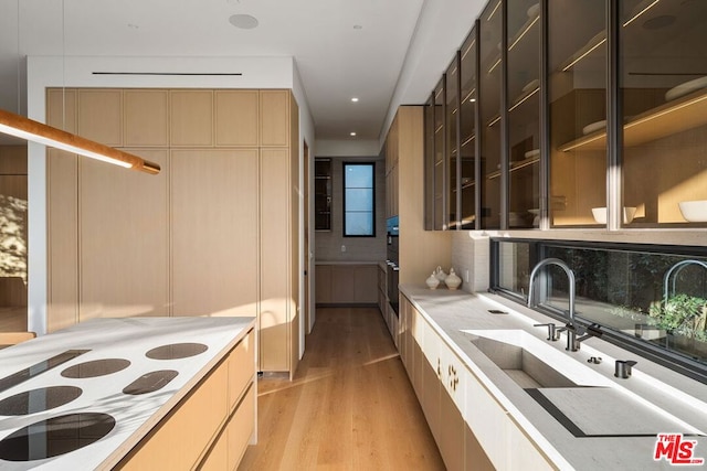 kitchen with sink, backsplash, and light hardwood / wood-style floors