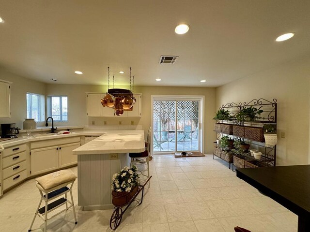 kitchen featuring white cabinetry, a breakfast bar, and sink