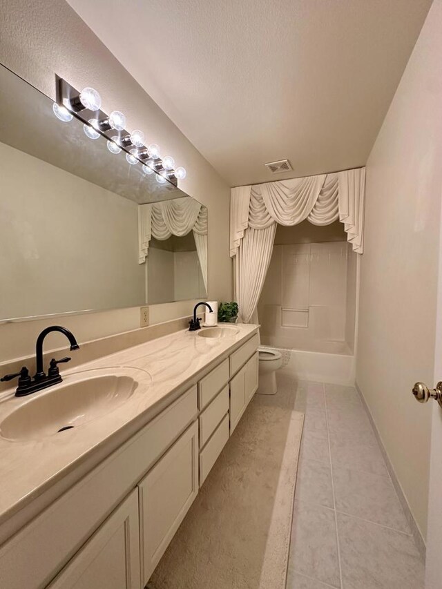 full bathroom with a textured ceiling, tile patterned flooring, vanity, toilet, and shower / bathtub combination