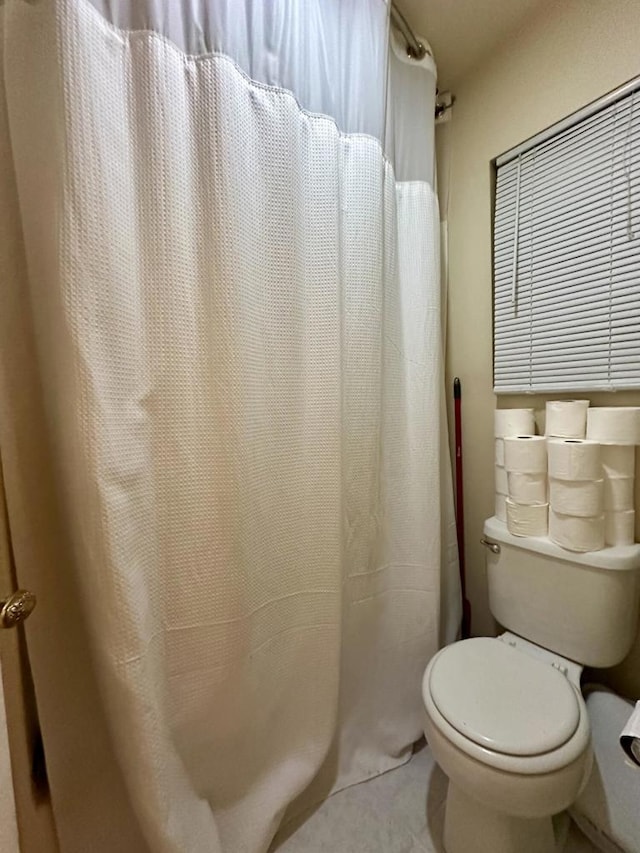 bathroom with toilet and tile patterned flooring