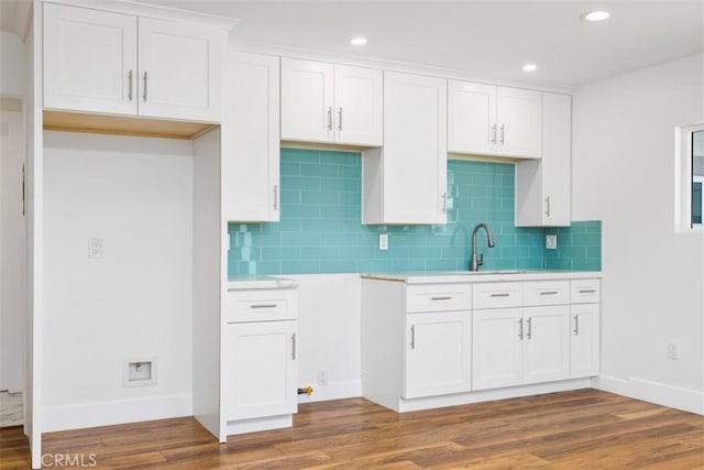 kitchen featuring dark hardwood / wood-style flooring, white cabinetry, and tasteful backsplash