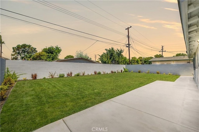 yard at dusk featuring a patio area