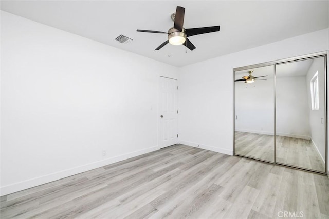 unfurnished bedroom with ceiling fan, light hardwood / wood-style floors, and a closet