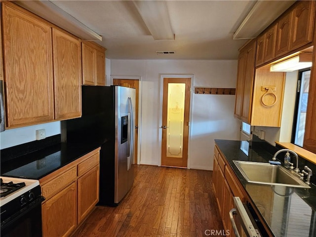 kitchen featuring white gas stove, stainless steel fridge, sink, and dark wood-type flooring