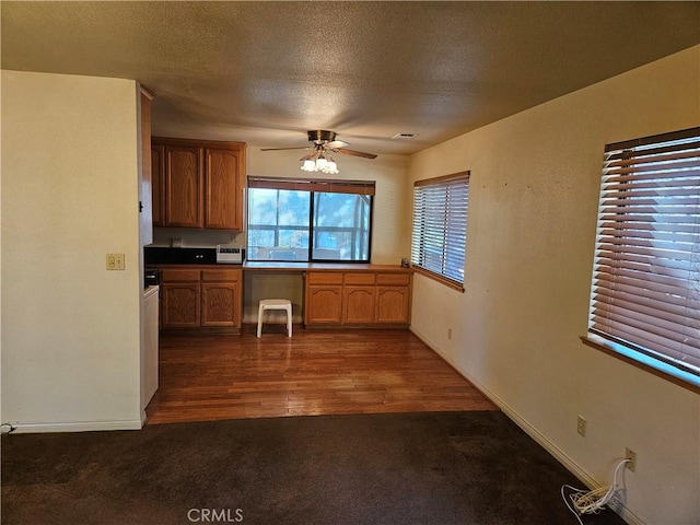 kitchen featuring a textured ceiling, ceiling fan, and dark wood-type flooring