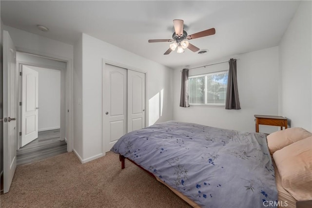 bedroom featuring ceiling fan, dark carpet, and a closet