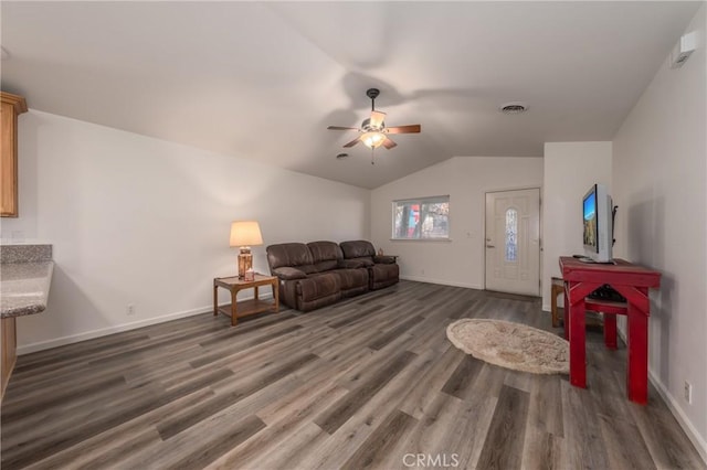 living room with ceiling fan, lofted ceiling, and dark wood-type flooring