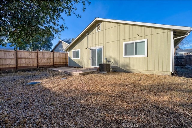 rear view of house with central AC unit and a patio