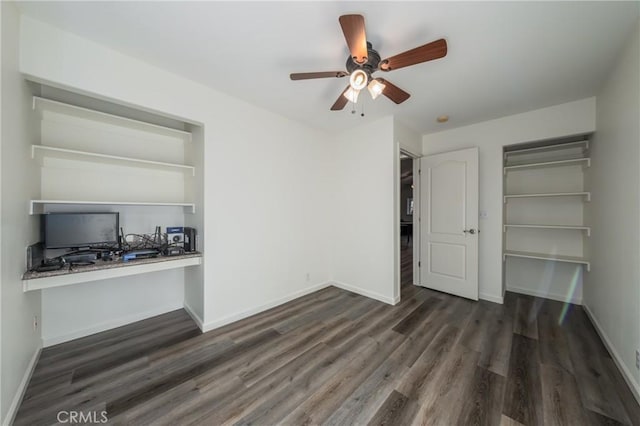 unfurnished bedroom with ceiling fan, dark hardwood / wood-style flooring, and built in desk