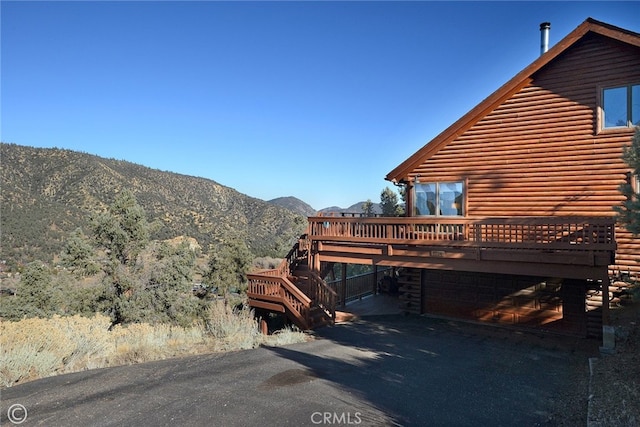 view of home's exterior featuring a garage and a deck with mountain view