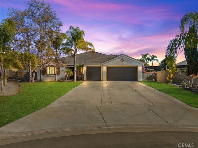 ranch-style home with a garage and a lawn