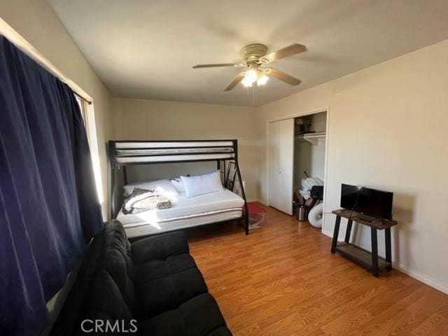 bedroom with a closet, hardwood / wood-style flooring, and ceiling fan