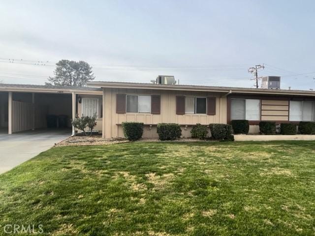 ranch-style home featuring a carport and a front lawn