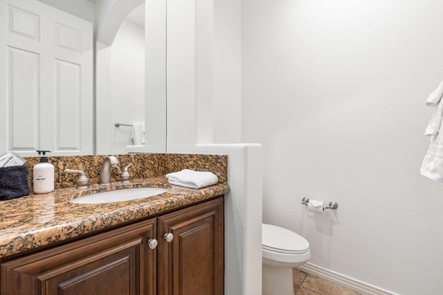 bathroom featuring tile patterned flooring, vanity, and toilet