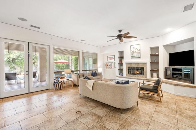 living room with ceiling fan, built in shelves, and french doors