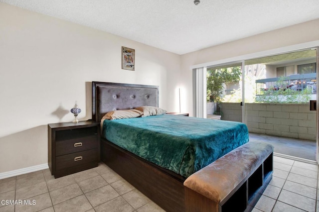 tiled bedroom featuring access to exterior and a textured ceiling