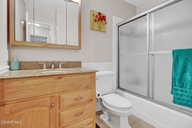 full bathroom featuring shower / bath combination with glass door, tile patterned flooring, vanity, and toilet