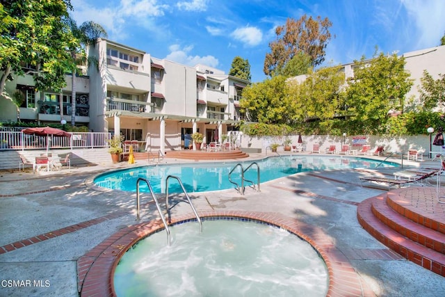 view of swimming pool with a community hot tub and a patio area