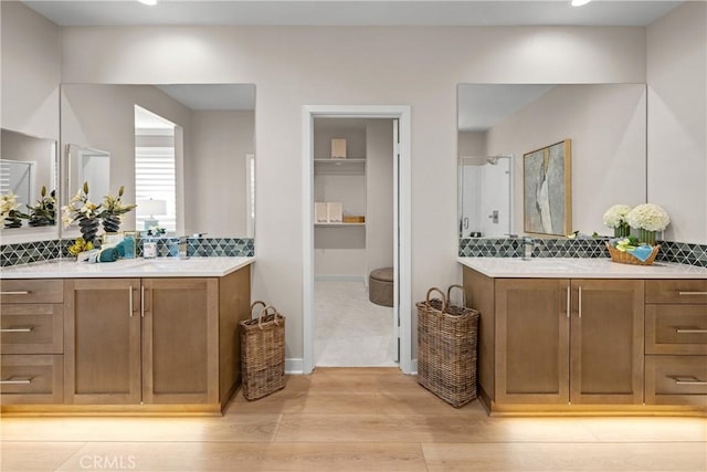 bathroom featuring vanity, backsplash, and hardwood / wood-style flooring