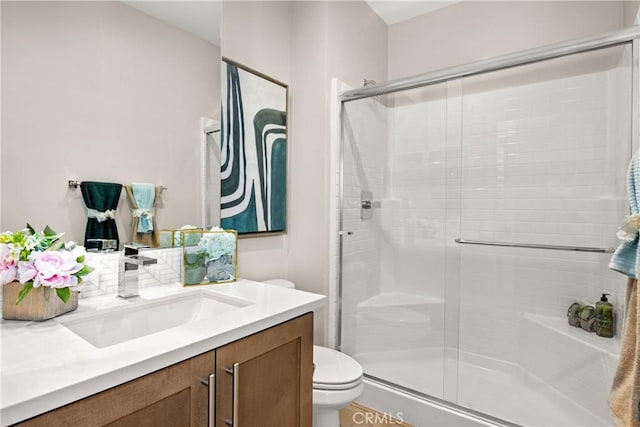 bathroom with vanity, toilet, and a shower with shower door