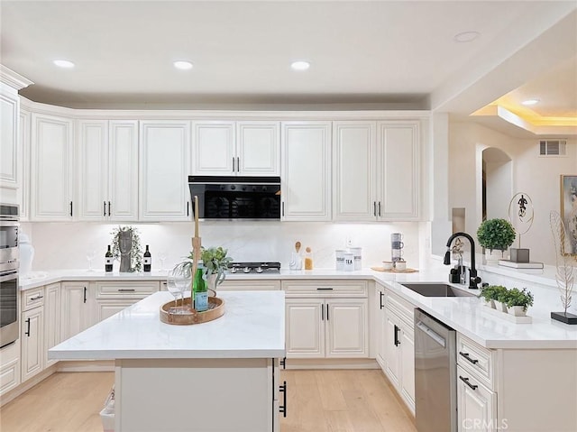 kitchen with dishwasher, sink, white cabinets, and light hardwood / wood-style flooring