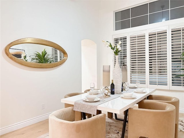 dining space with a high ceiling and light hardwood / wood-style floors