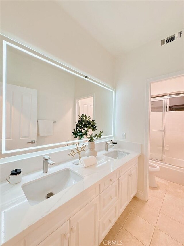 full bathroom featuring tile patterned flooring, vanity, toilet, and shower / bath combination with glass door