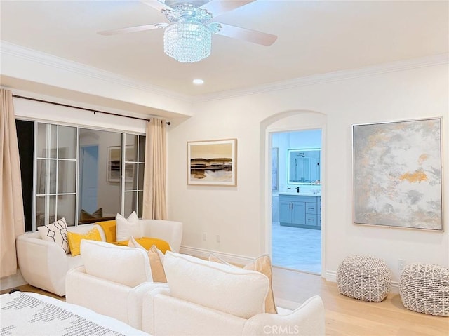 living room with wood-type flooring, ceiling fan, and ornamental molding