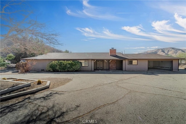 single story home featuring a mountain view and a garage