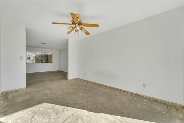 unfurnished room with ceiling fan and concrete flooring