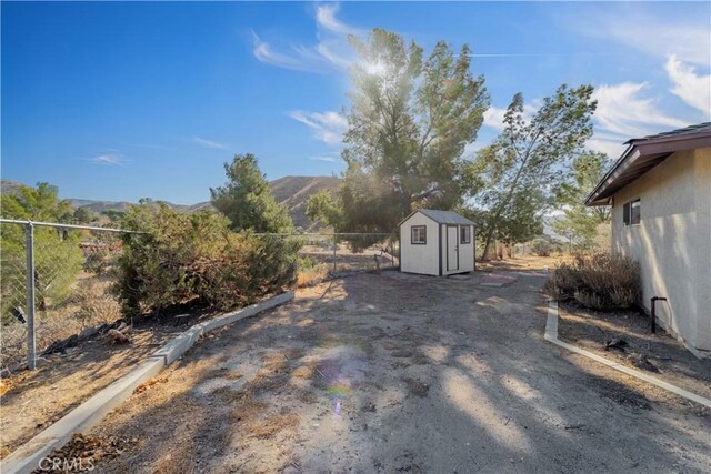 view of yard featuring a mountain view and a storage unit