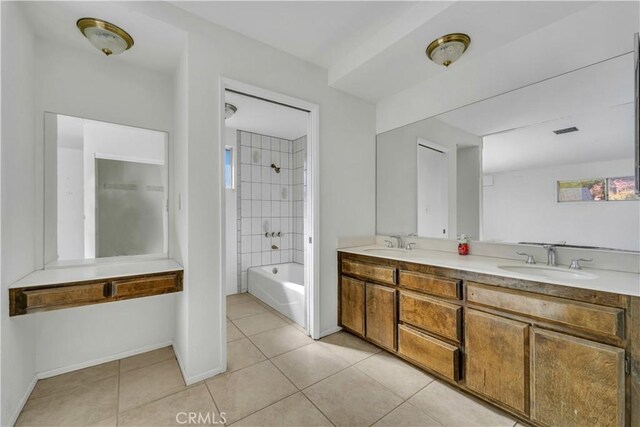 bathroom featuring tile patterned flooring, tiled shower / bath combo, and vanity