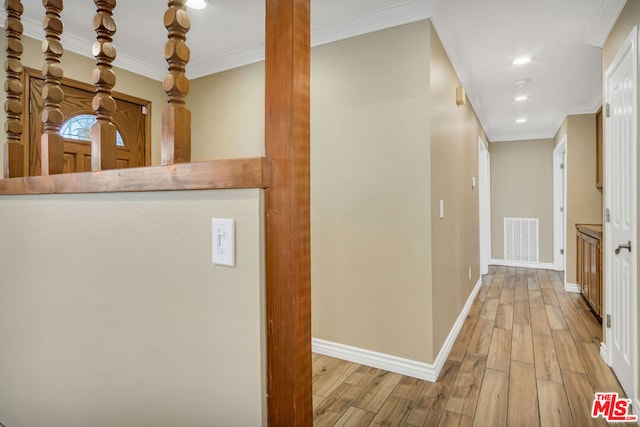 hallway with ornamental molding and light wood-type flooring