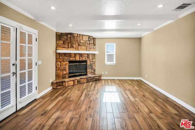 unfurnished living room featuring beam ceiling, crown molding, a fireplace, and hardwood / wood-style flooring