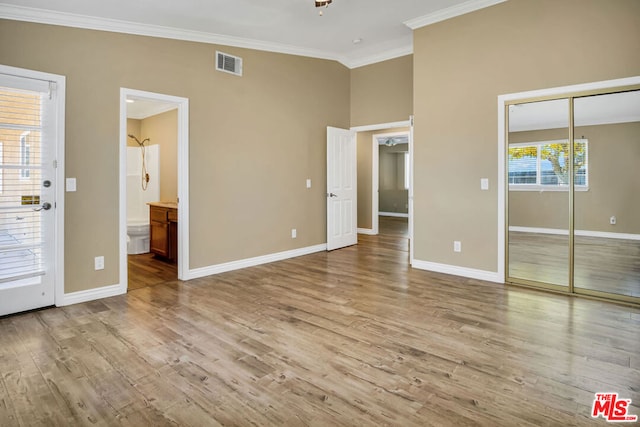 unfurnished bedroom with multiple windows, light hardwood / wood-style floors, and ornamental molding