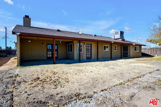 rear view of property featuring central AC unit and a patio area