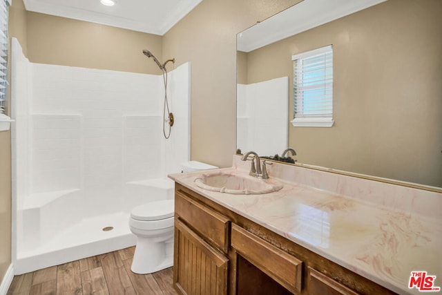 bathroom with walk in shower, vanity, crown molding, hardwood / wood-style flooring, and toilet