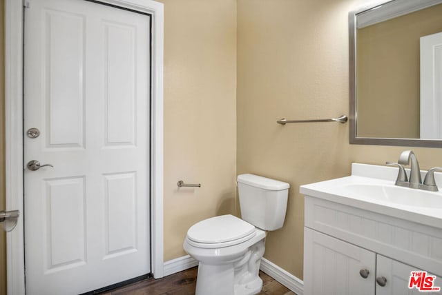 bathroom featuring hardwood / wood-style floors, vanity, and toilet