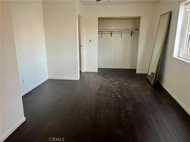 unfurnished bedroom featuring dark hardwood / wood-style flooring and a closet