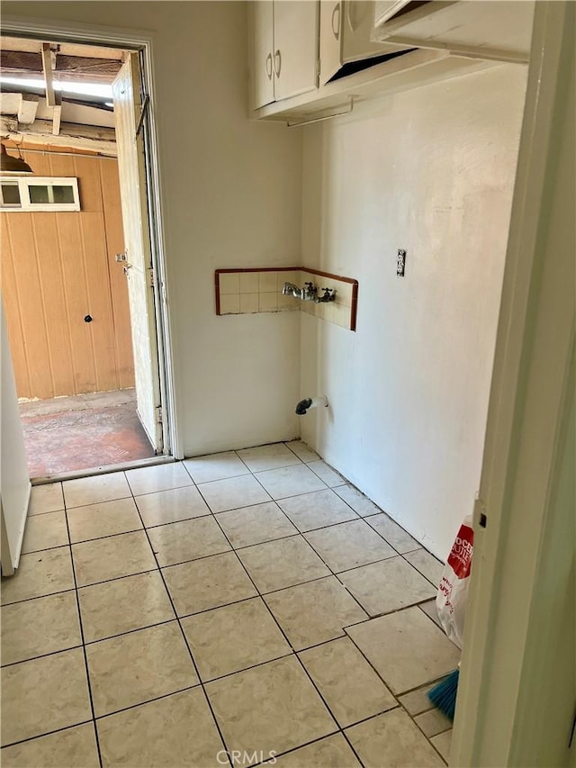 laundry room featuring washer hookup, light tile patterned flooring, and cabinets